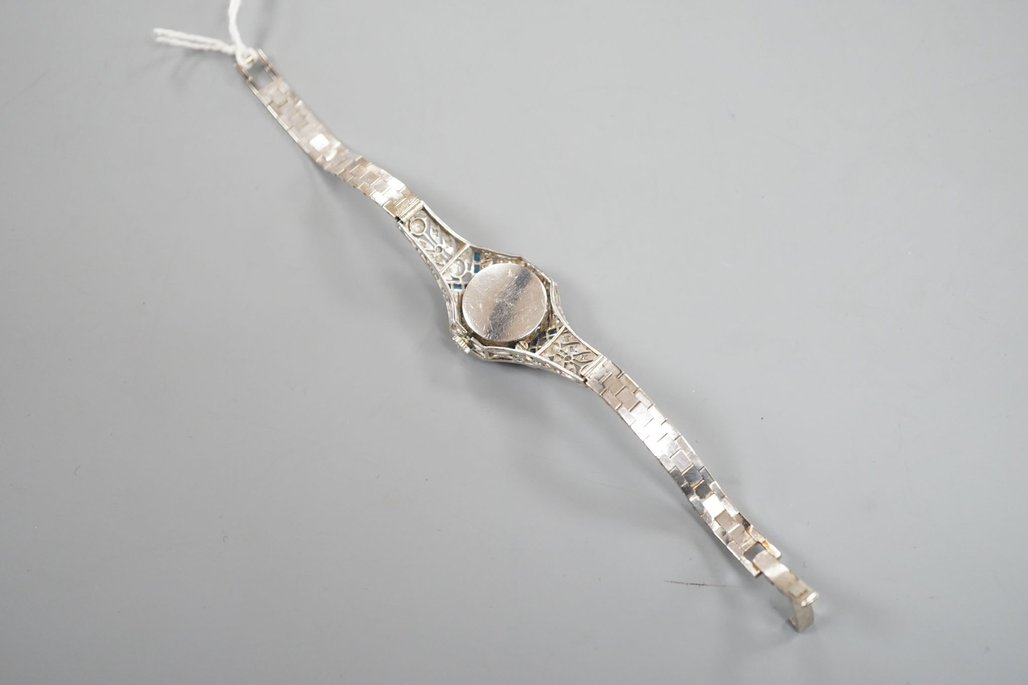 A mid 20th century white metal, synthetic sapphire? and diamond set cocktail watch, with Bucherer manual wind movement and dial bearing the signature Cartier, on a 14k white metal bracelet, case diameter 22mm, gross weig